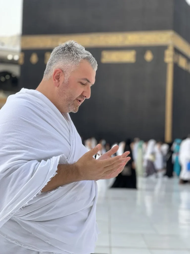 Kâbe önünde ihramla dua eden hacı